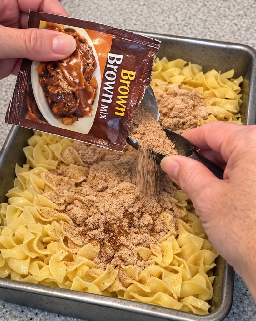 Pour brown gravy mix and these 3 ingredients over egg noodles into a baking pan