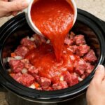 Pour tomato soup over raw stew meat, paired with these 2 ingredients, into slow cooker